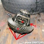Remove the final drive gear set (A) by removing the 10 bolts and tapping the gear off.  Then tap the pinion mate shaft (B) out of the housing using a 3/8" socket extension on the shaft at (C).