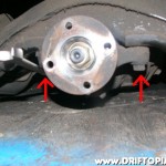 Remove the two indicated bolts from the front of the differential housing.
