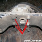 Remove the four nuts from the rear of the housing and then slowly move the differential forward and down using the hydraulic jack.