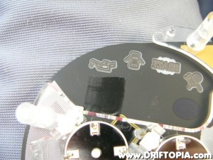 Flip the cluster face over and place a small piece of eletric (black) tape over the back side of the P/S etching.