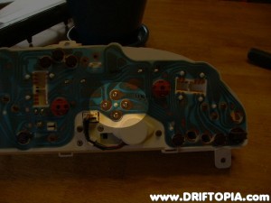 Remove the four highlighted screws and pull the speedometer out of the cluster.