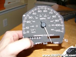 Once inserted, bend the tab back down and then place the odometer behind the window to verify its alignment.