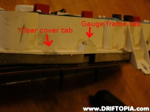 Remove the clear plastic cover and then the plastic gauge frame by depressing the tabs around the housing.