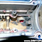 ca18detottpulsarmanifold212 This is the inside of the valve cover (at the nipple) after threading a new fitting into the hole. This whole process has been done becaue the over the top manifold makes the clearance of the valve cover vent line very tight.