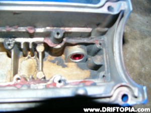 This is the inside of the valve cover (at the nipple) after threading a new fitting into the hole.  This whole process has been done becaue the over the top manifold makes the clearance of the valve cover vent line very tight.