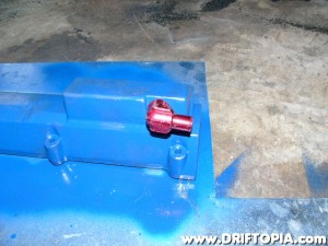 After painting the manifold, I tapped and then thread a new fitting into the outlet.  (Note: This fitting ended up not working because it faced directly into the front engine plate.  I ended up swapping it for a straight brass piece.  Pictured later.)