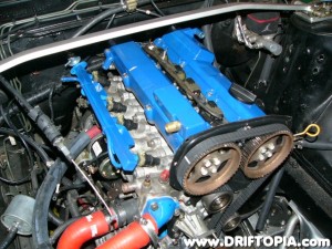 Now flip the valve cover over and clean the inside one more time to remove any debris the tapping may have caused.  Then reinstall the two plates using a thin strip of RTV on the edges.  Finally, install the valve cover back on the motor.  (Note the alternate brass fitting in the picture.)