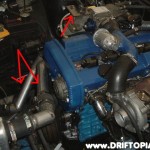 Here we have the new radiator lines (arrowed) and the mounting bracket (arrow) to secure the throttle cable to the top mount manifold.