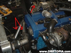 Here we have the new radiator lines (arrowed) and the mounting bracket (arrow) to secure the throttle cable to the top mount manifold.