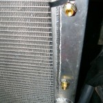 The 1/8" to 1/4" adapters installed in the transmission cooler of the radiator.