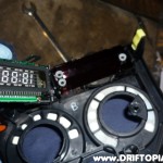 Once the tabs are lifted, pull the clock's circuit board out of the housing.