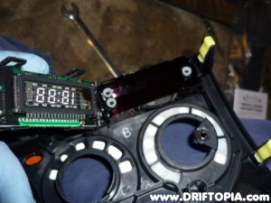 Once the tabs are lifted, pull the clock's circuit board out of the housing.
