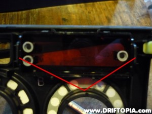 Press the two indicated tabs to pull the clock cover from the panel.