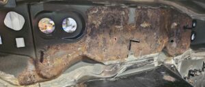 Surface rust present on the firewall of the NA Mazda Miata exo car.