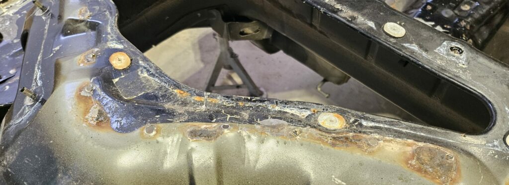 There are rust spots throughout the chassis of the NA Miata exo car donor chassis.