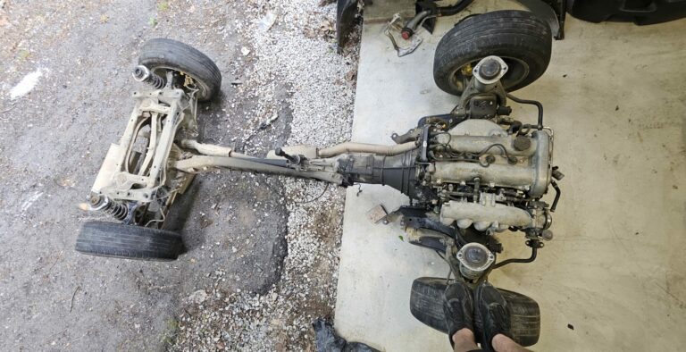 The subframe and drivetrain removed as a single piece from the 1991 NA Mazda Miata.