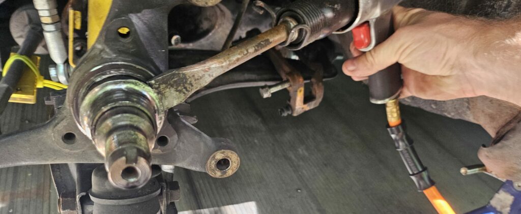 Air hammer being used to knock the inner race off the front spindle of the NA Miata MX-5.