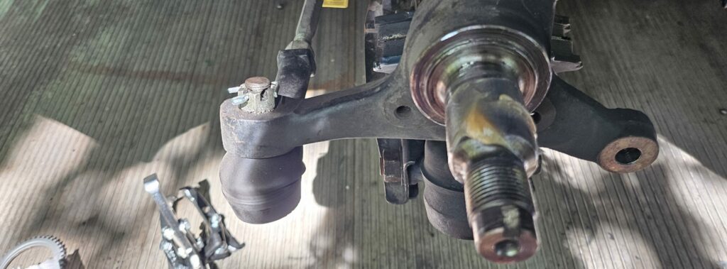 New wheel bearing grease applied to the front spindle of the NA Miata.