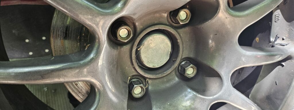 The shorter wheel studs on the replacement front wheel hub caused less than optimal engagement of the lug nuts.