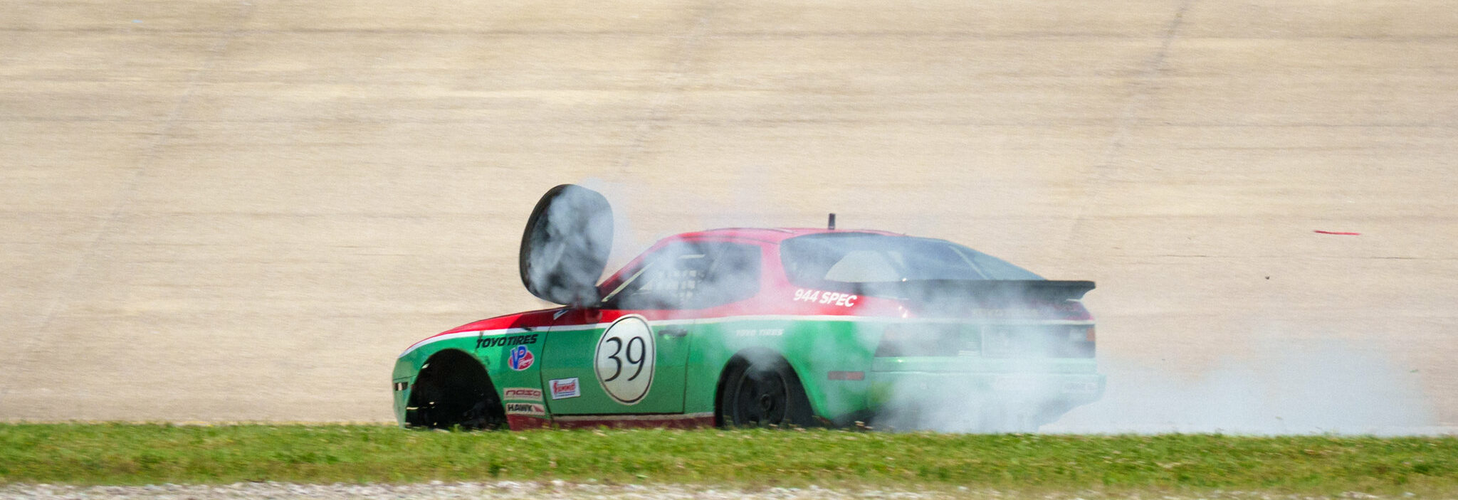 944 Spec racecar with broken spindle threw wheel into the windshield.