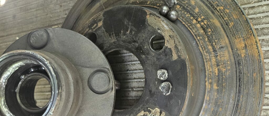 NA Miata MX-5 hub removed with the damaged ball bearings from the wheel bearing exposed.
