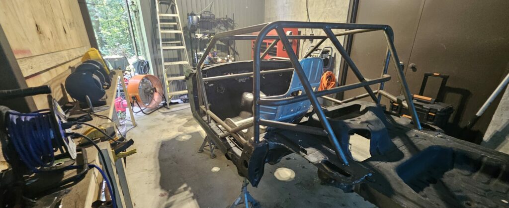 The main roll hoop is triangulated to the rear strut tower mounts.