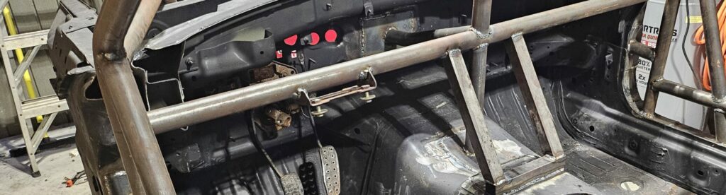 The factory steering column mount welded to the new dash bar of the roll cage on the ghettocet miata.