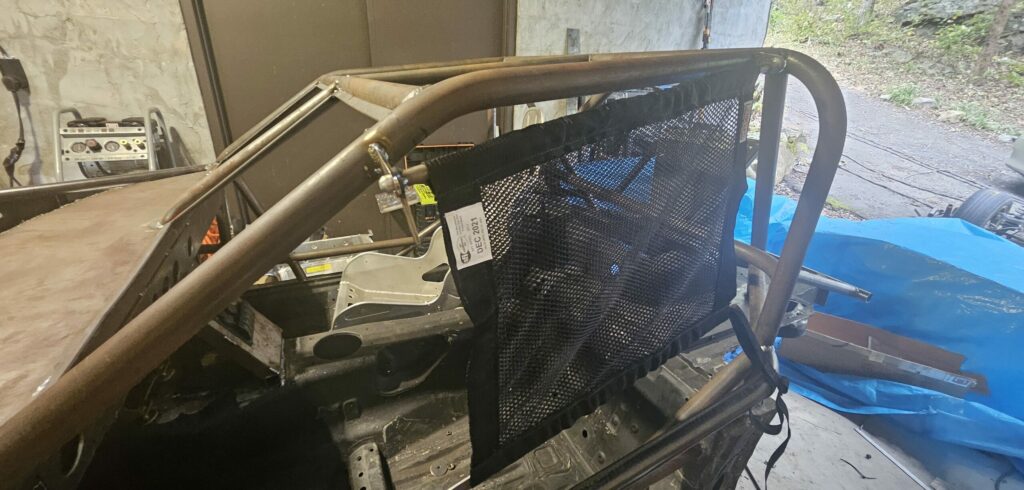 The window net mounted to the roll cage of the NA Miata exo car ghettocet.