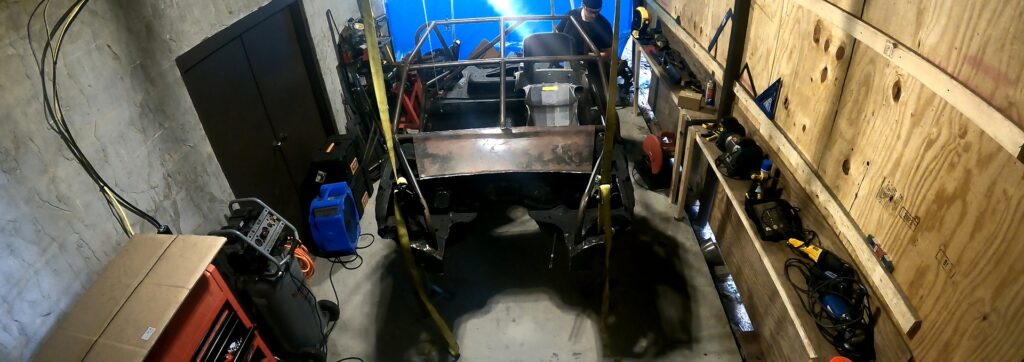 Using four tow straps as a lift to raise the exo car chassis high enough in the air to slide the front subframe under.