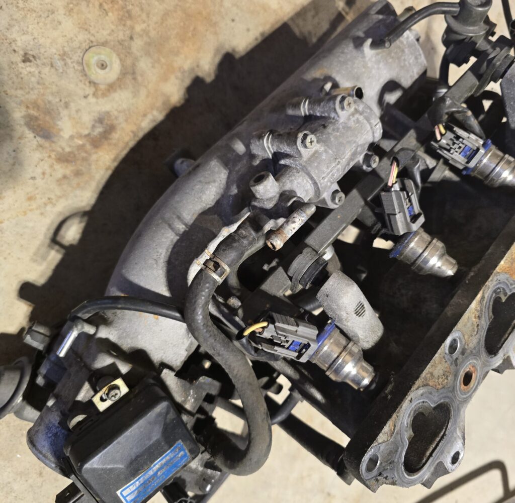 The analog Air Valve on the top side of the NA Miata 1.6l Intake Manifold.