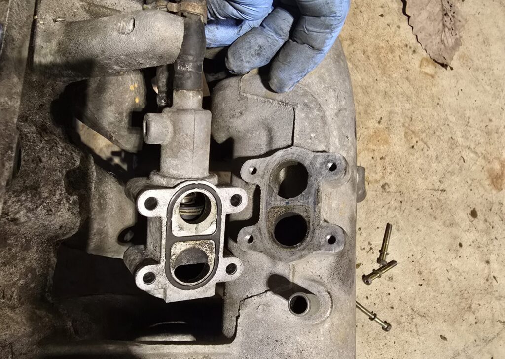 The analog Air Valve removed from the NA Miata 1.6 intake manifold flipped over to show the operating mechanism inside.