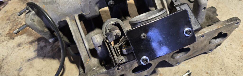 Block off plate attached with new hardware on the na miata throttle body.