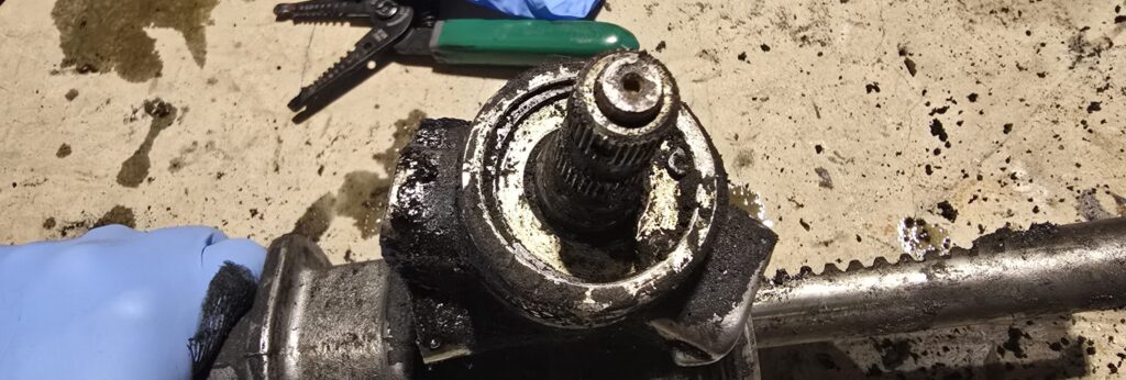 The snap ring on the top of the miata steering pinion.