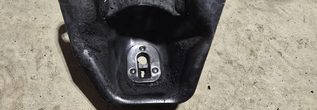 Cleaning the backside of the engine mount bracket with a wire wheel before welding.