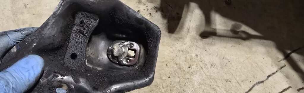 Tack welds holding the bolt and washer to the engine bracket.