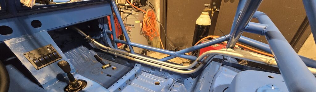 The hot side runs on top of the cold side coolant line to complate the coolant loop on the NA Miata's rear mounted radiator.